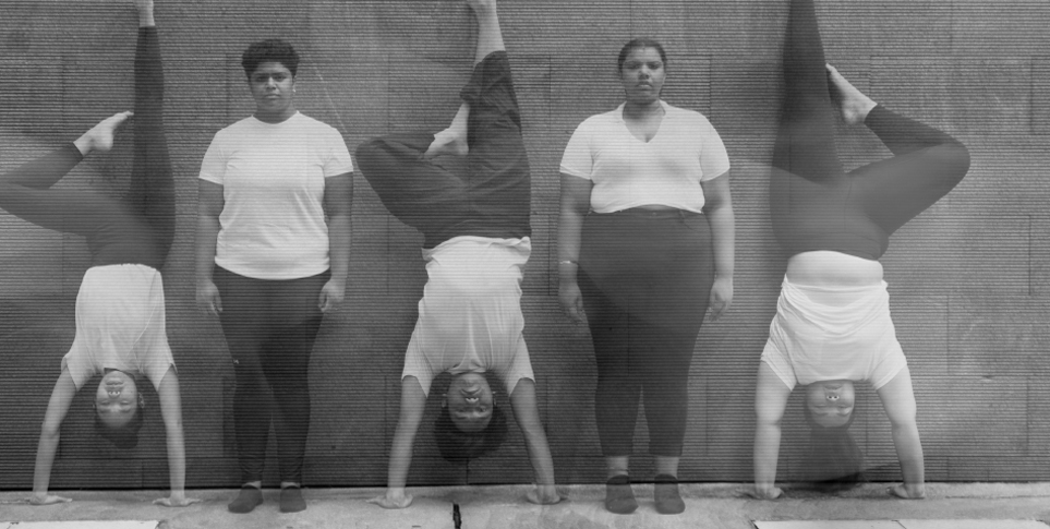 A hazy greyscale photo of 5 young people in a row, alternately in handstand and standing positions.